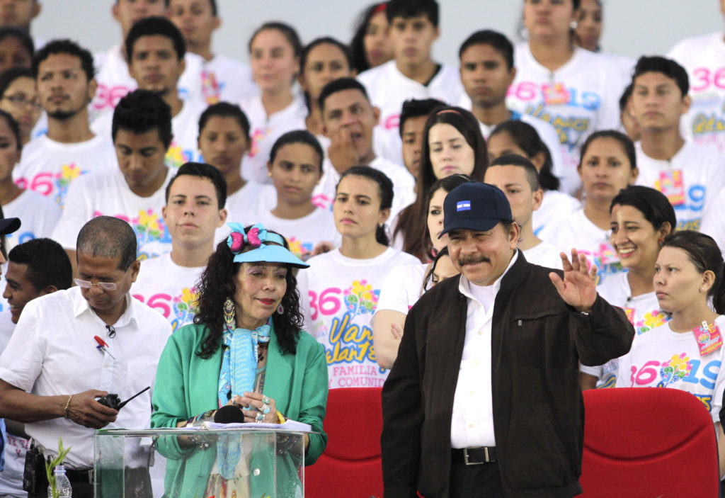 President Ortega flanked by Sandinista Youth with their distinctive shirts
