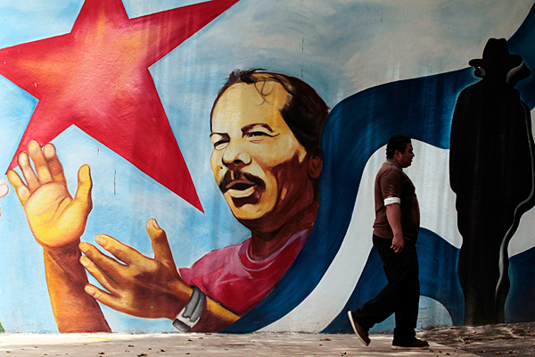Wall mural of Ortega with national flag and red star.