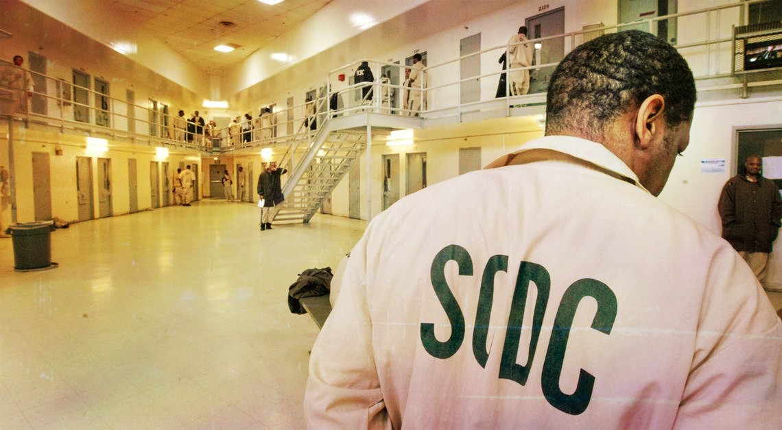 Image of inside a South Carolina prison. Two stories of cells in background and prison with with SCDC on uniform in foreground.
