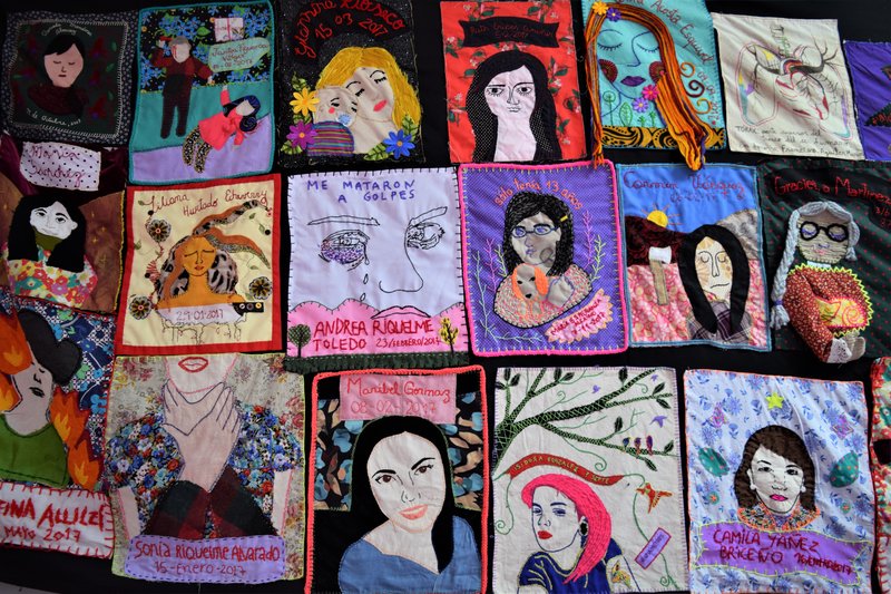 Quilt composed of squares portraying woman lost to femicide along with names. 