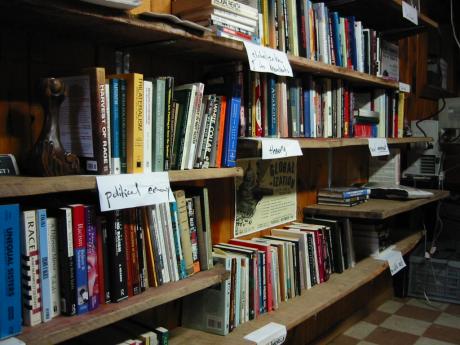 Image of a book shelf with hand written section labels.