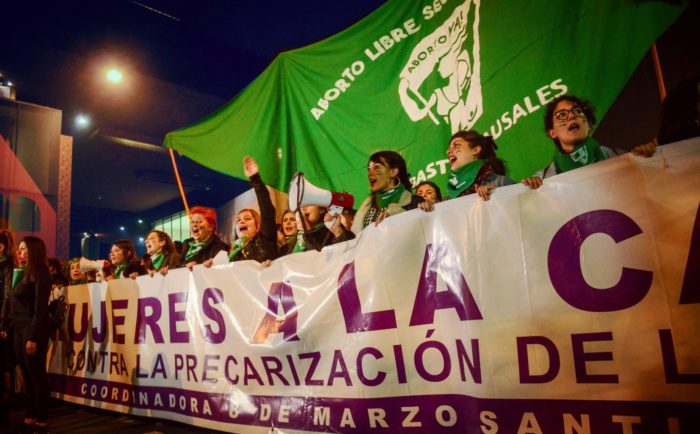 Women holding a banner leading a abortion rights protest in Chile. 